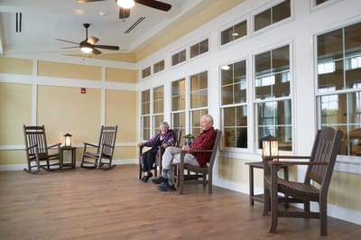 Residents relaxing in a common area with rocking chairs