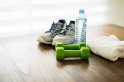 Dumbbell, shoes, and water bottle on a table