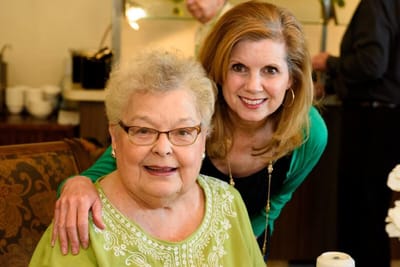 Resident and staff member smiling together
