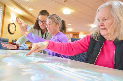 Residents engaging in an interactive activity with staff assistance