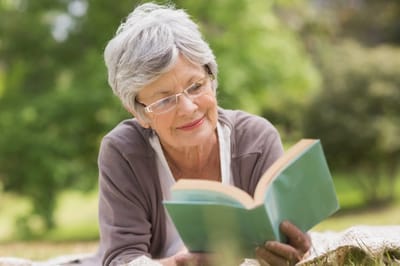 Senior woman reading a book in a garden
