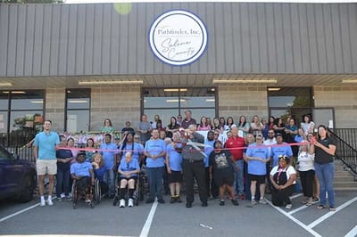 Grand opening ceremony with staff and residents outside the facility