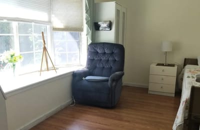 Cozy resident room with a recliner and natural light