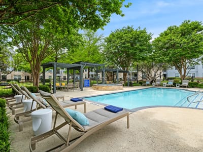 Outdoor pool area with lounge chairs and greenery