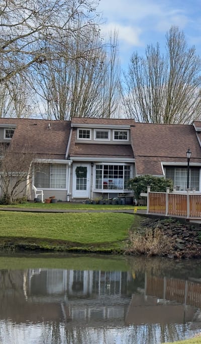 Exterior view of a senior living facility by a pond
