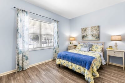 A nicely decorated resident room with flowers and artwork
