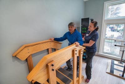 A staff member assisting a resident with therapy equipment