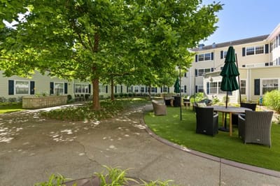 A scenic outdoor area with seating under trees