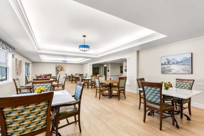 Bright dining room with tables and chairs arranged for residents