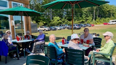 Residents enjoying a meal outside under umbrellas