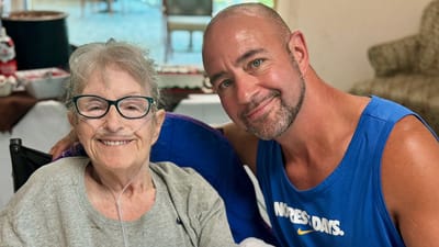 A smiling resident with a caregiver indoors