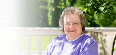 Smiling resident relaxing on a patio