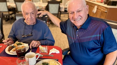Two residents enjoying lunch in a dining area