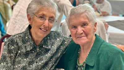 Two smiling residents posing together at a social event