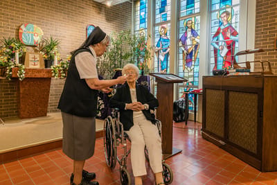 Residents interacting in a beautifully lit chapel setting