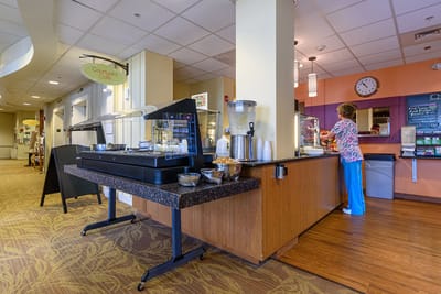Resident serving food in the dining area