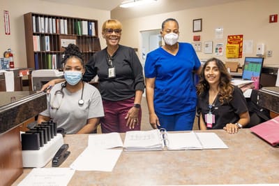 Four staff members smiling at a reception area