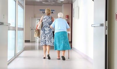 Caregiver assisting resident in a hallway