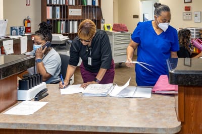 Staff members working at a reception desk