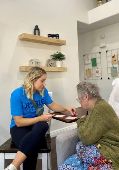 Resident and staff engaging in a game in a common area