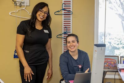 Two staff members smiling in a facility common area