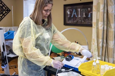 Staff member preparing equipment in a therapy room