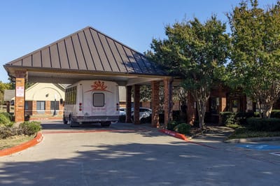 Front entrance of Park Manor McKinney with a shuttle van
