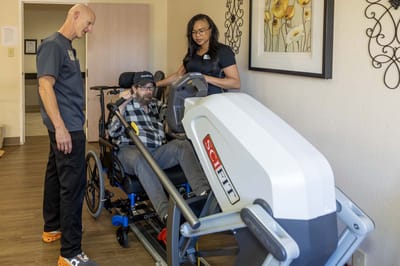 Therapist assisting a resident with fitness equipment
