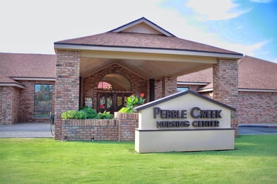 Exterior view of Pebble Creek Nursing Center with signage