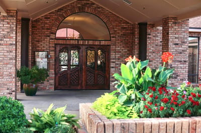 Entrance of Pebble Creek Nursing Center with flowers.