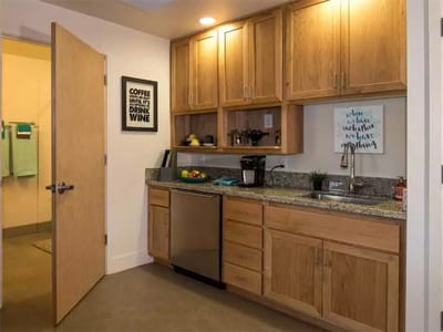 Modern kitchenette with wooden cabinets and granite countertops