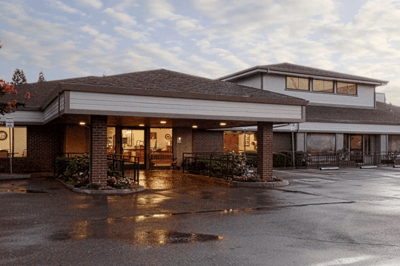Exterior view of Pine Creek Care Center with flowers and walkway