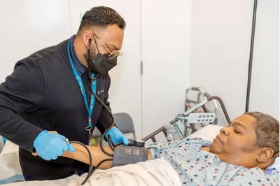 Medical staff assisting a resident with blood pressure check
