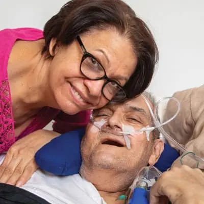 A woman smiling with an elderly man in a care setting
