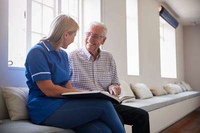 Caregiver and resident having a conversation on a bench