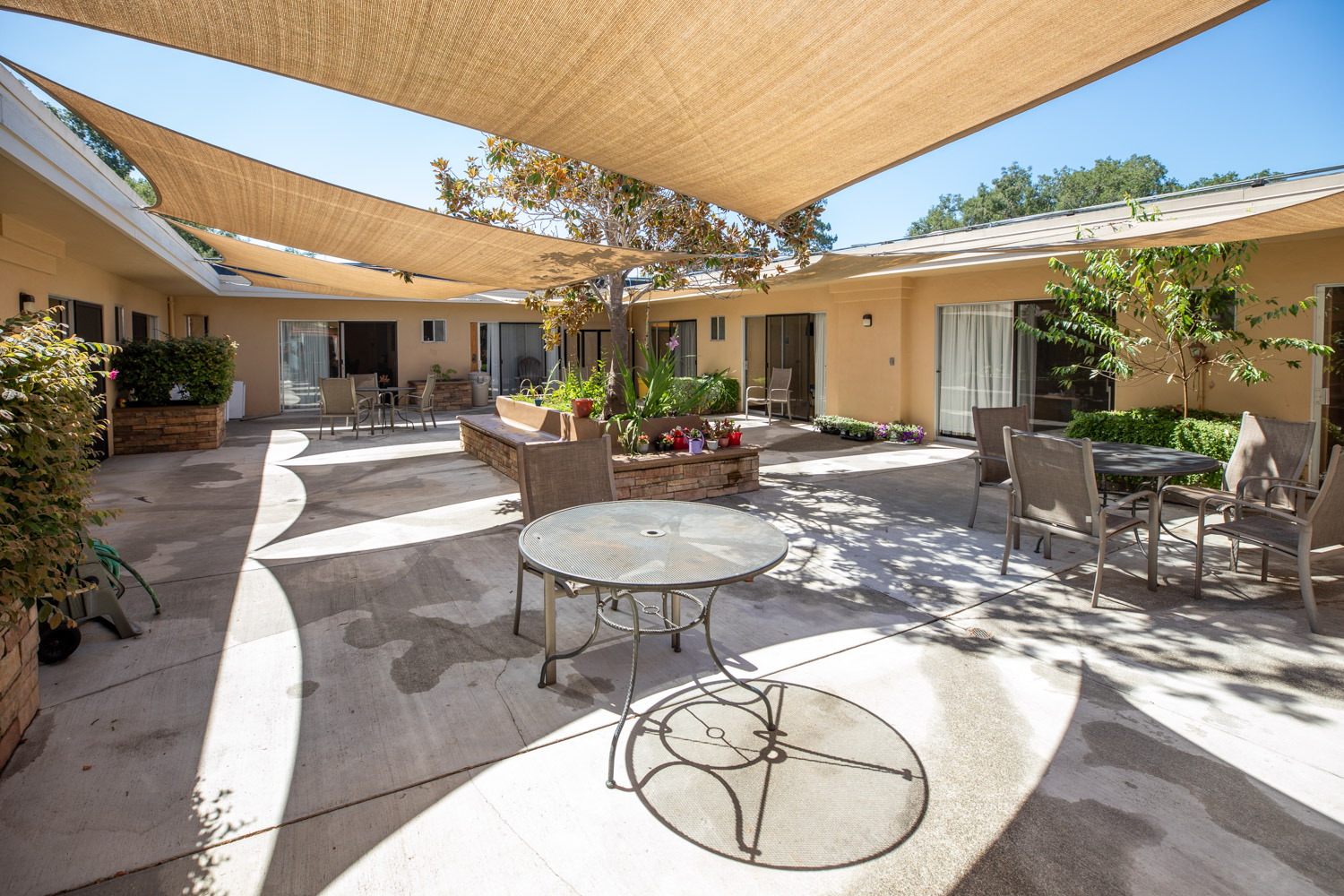 A sunny outdoor courtyard with seating areas and shade