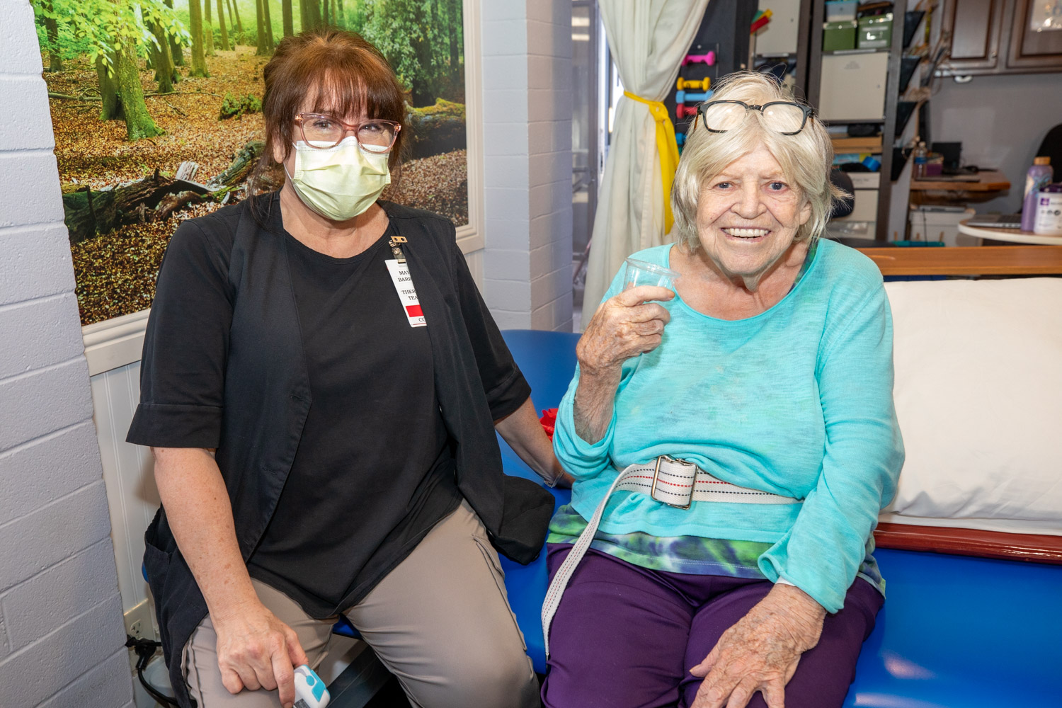A staff member and a resident smiling together in a common area