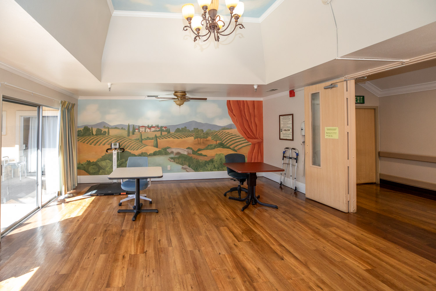 Bright activity room with wooden flooring and mural