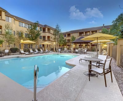 Outdoor pool area with seating and umbrellas