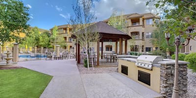 Outdoor area with grill and seating near the pool