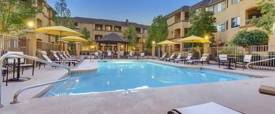 Resort-style pool area with lounge chairs and umbrellas