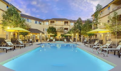 Swimming pool area with lounge chairs and umbrellas