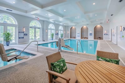 Indoor swimming pool area with seating and access equipment