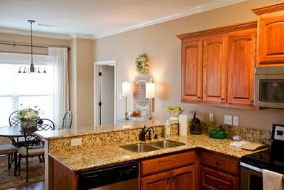An interior kitchen space with wooden cabinets