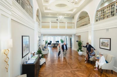 Bright interior lobby with residents and staff interacting
