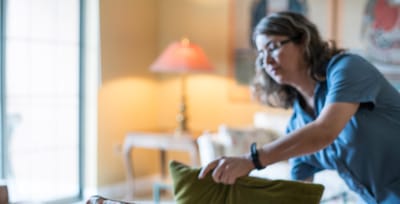 Staff member arranging pillows in a cozy common area