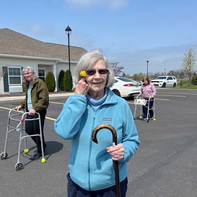 Residents enjoying time outdoors in the facility's parking area