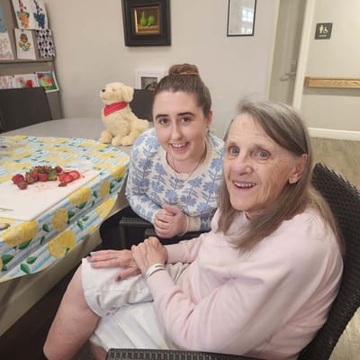 A resident and staff member smiling together