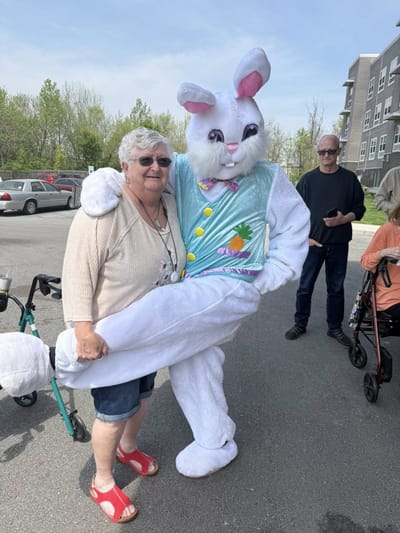 Resident posing with an Easter Bunny character outdoors