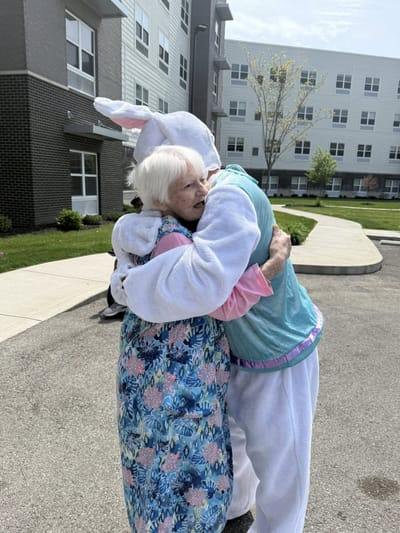 Resident and staff member in bunny costume hugging outside